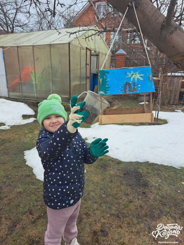 Повесила кормушки в саду.